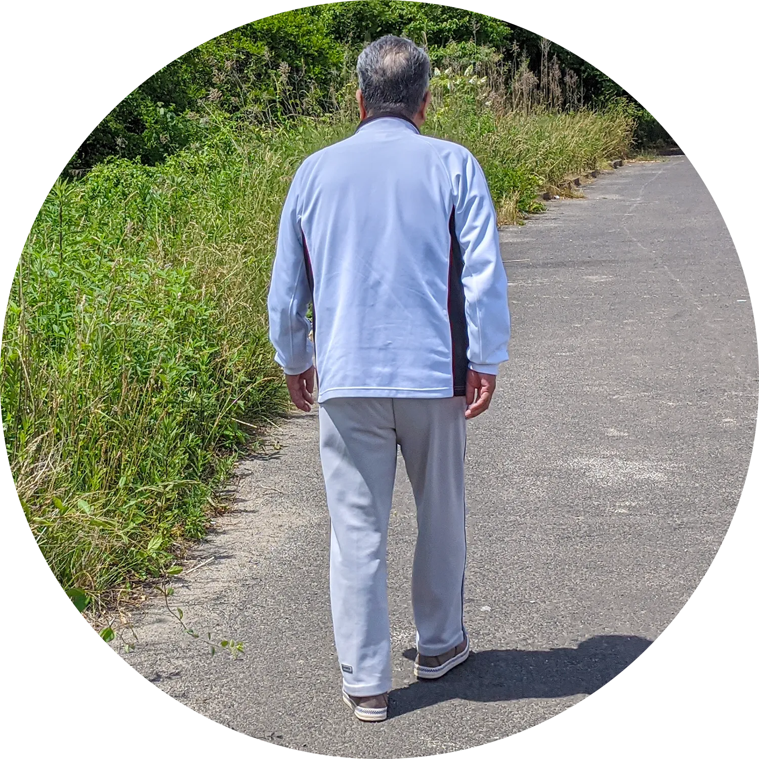 一人で道を歩く高齢男性の写真