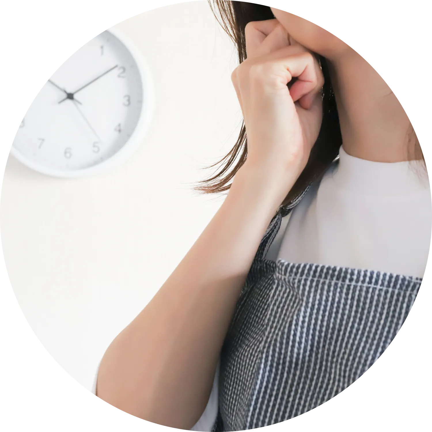 10時過ぎの時計と頬に手を当てる女性の写真