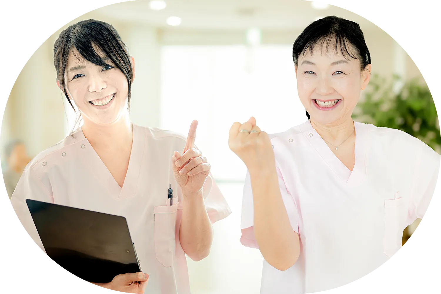笑顔でガッツポーズをする看護師と介護士の写真