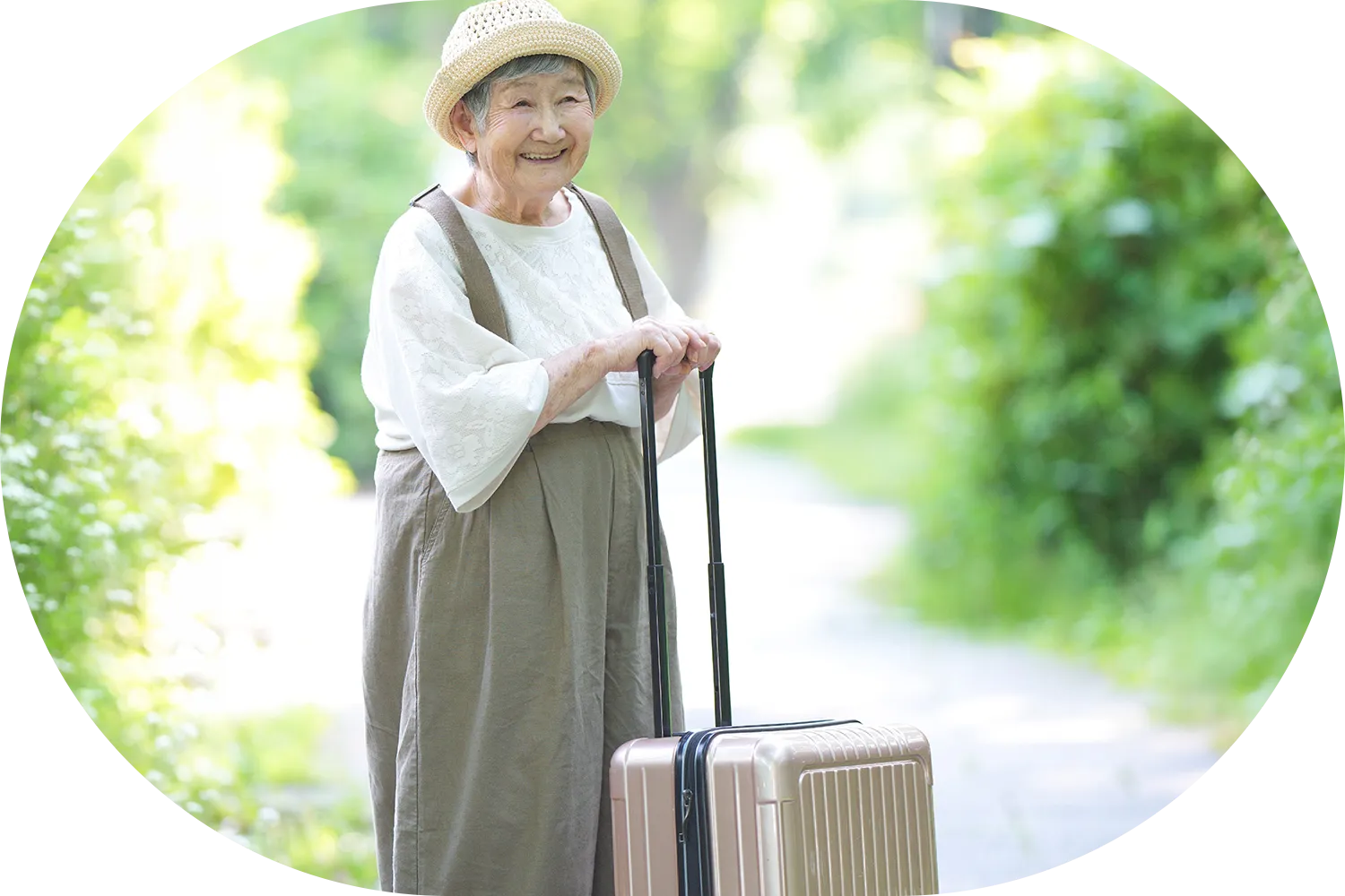旅行用キャリアケースを手にした高齢女性の写真